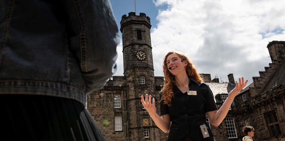 Tour guide with microphone talking to guest