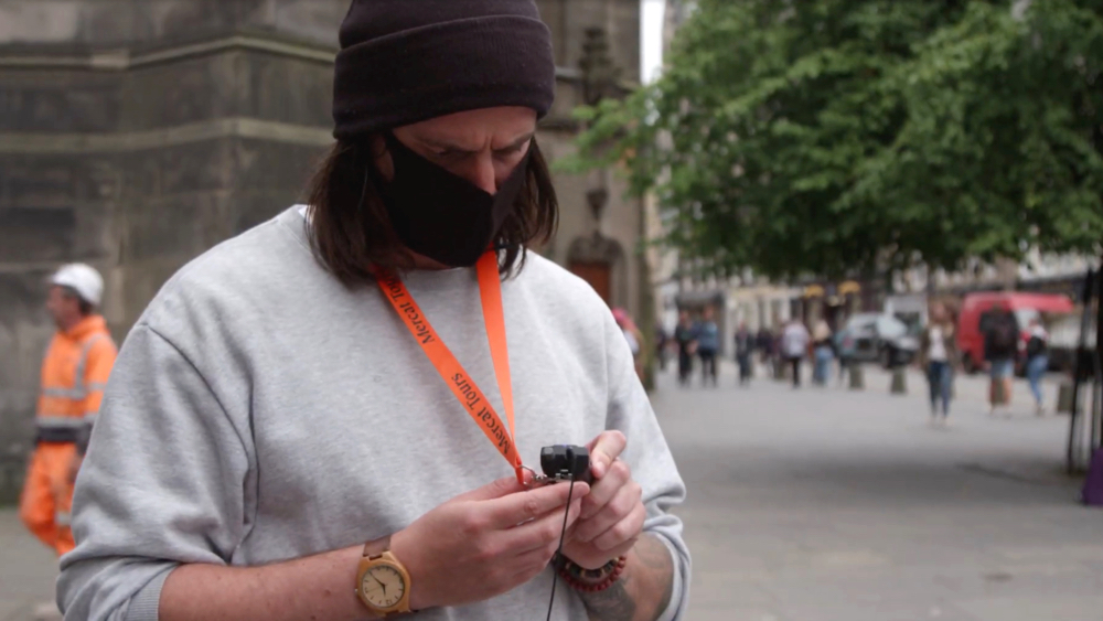 Tourist using a tour guide system wearing a face mask in city centre